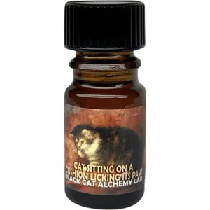 Black Phoenix Alchemy Lab Cat Sitting On A Cushion Licking Its Paw perfume bottle
